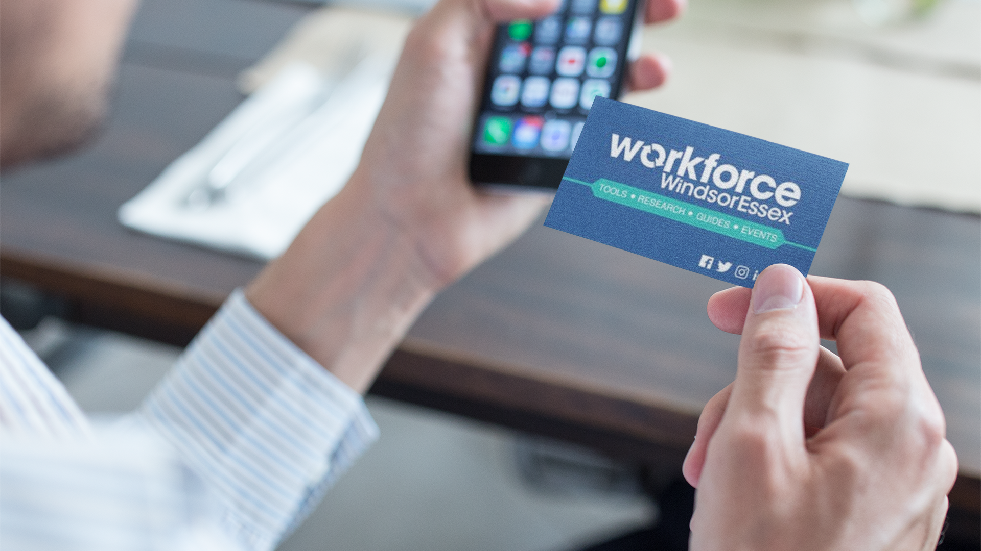 Person holding Workforce WindsorEssex business card