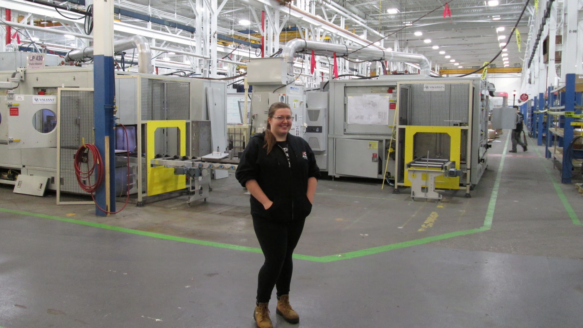 Woman posing inside manufacturing facility