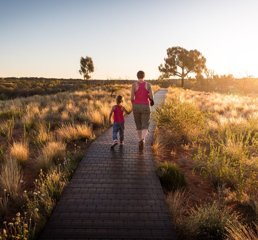 Woman and child walking along path outdoors