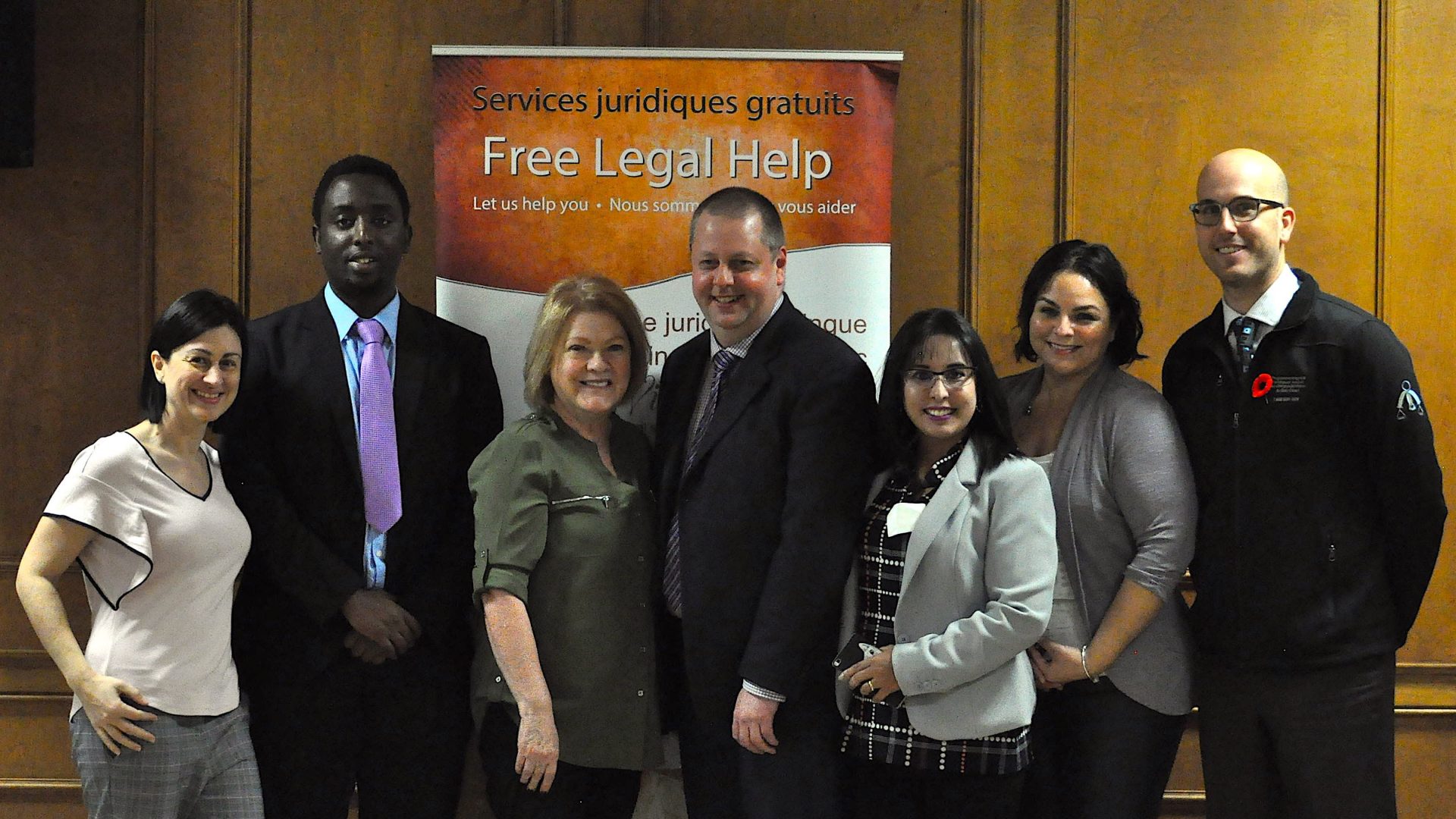 Bilingual Legal Clinic group photo in front of banner