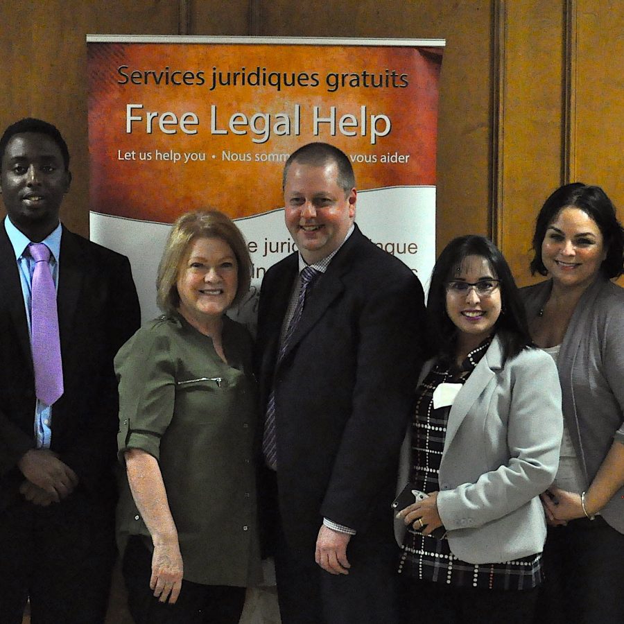 Bilingual Legal Clinic group photo in front of banner
