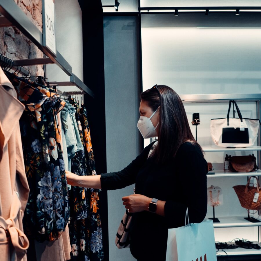 Woman looking at clothing wearing a mask